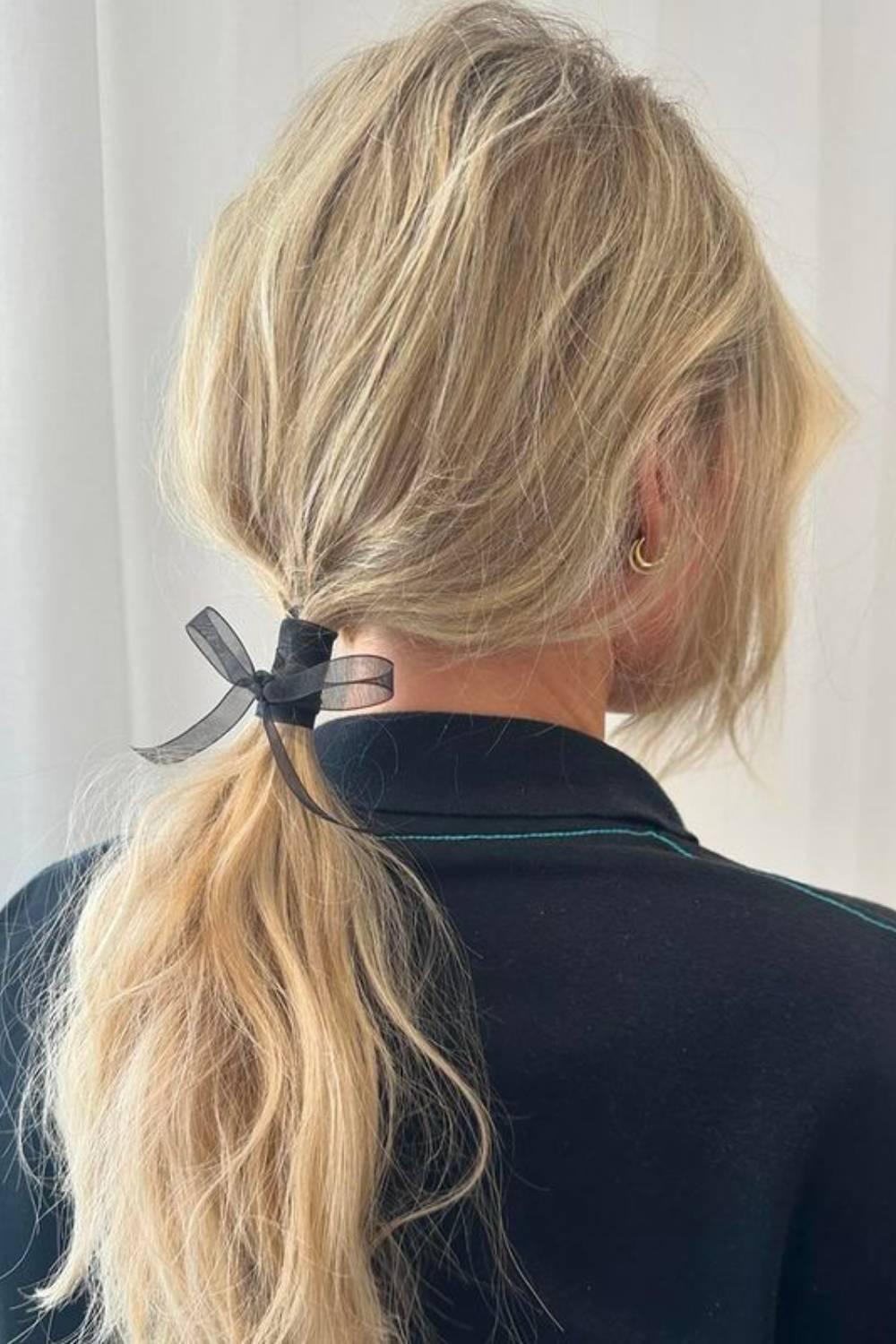Tousled low ponytail decorated with a silk ribbon bow