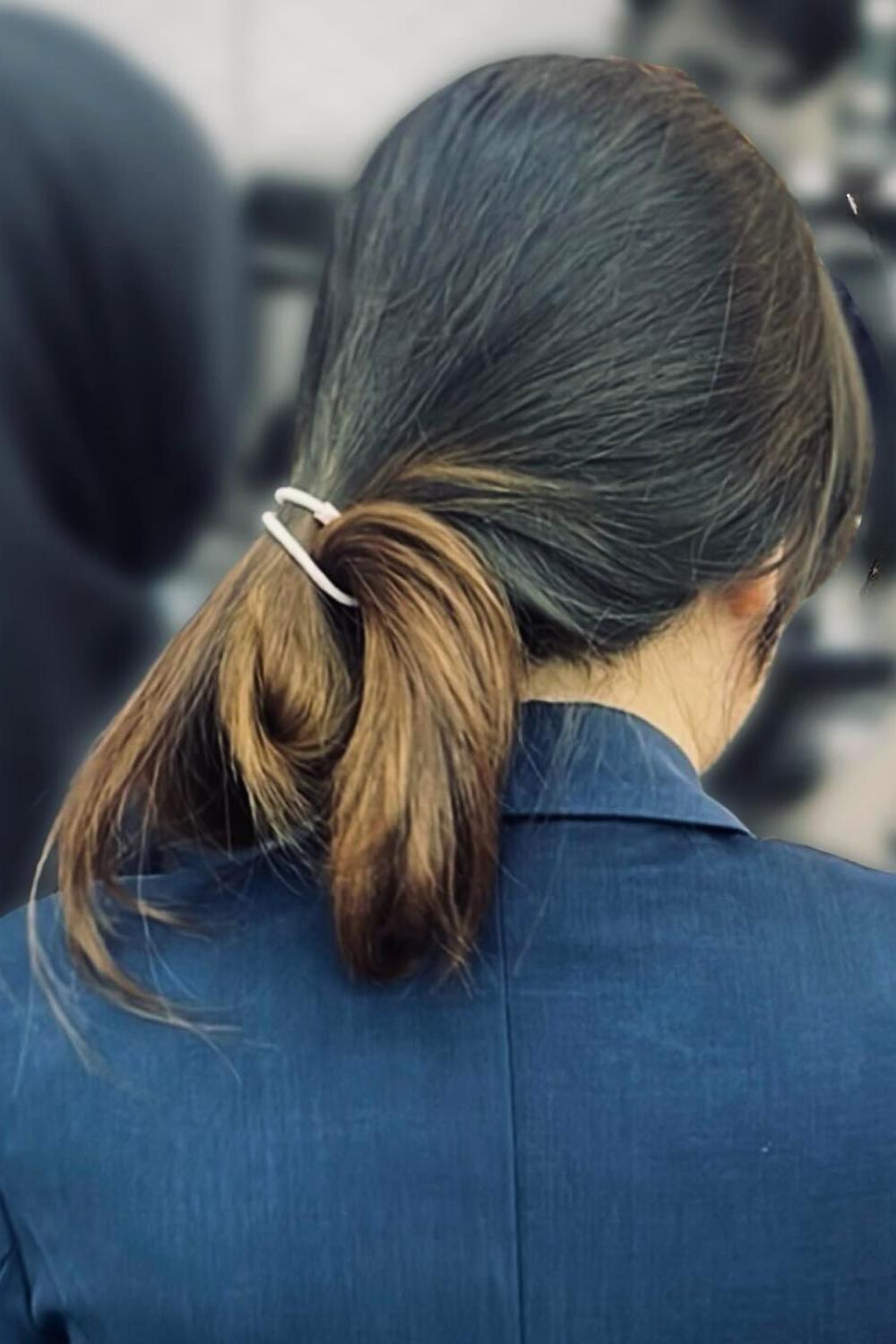 Contemporary low ponytail secured with sleek metal bar accessory