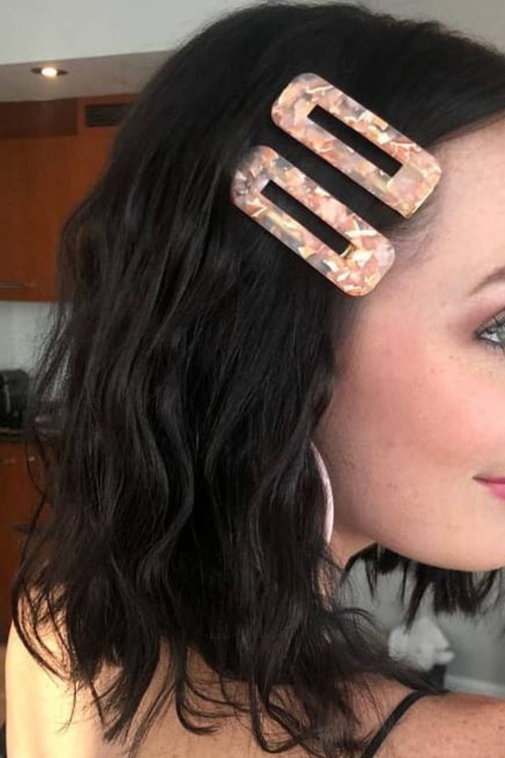 Wavy hair styled with decorative metallic clips on one side