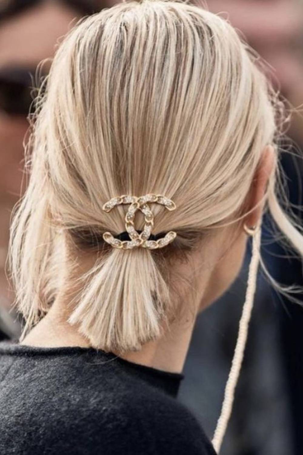 Sleek low ponytail styled with a chic metal clasp accessory
